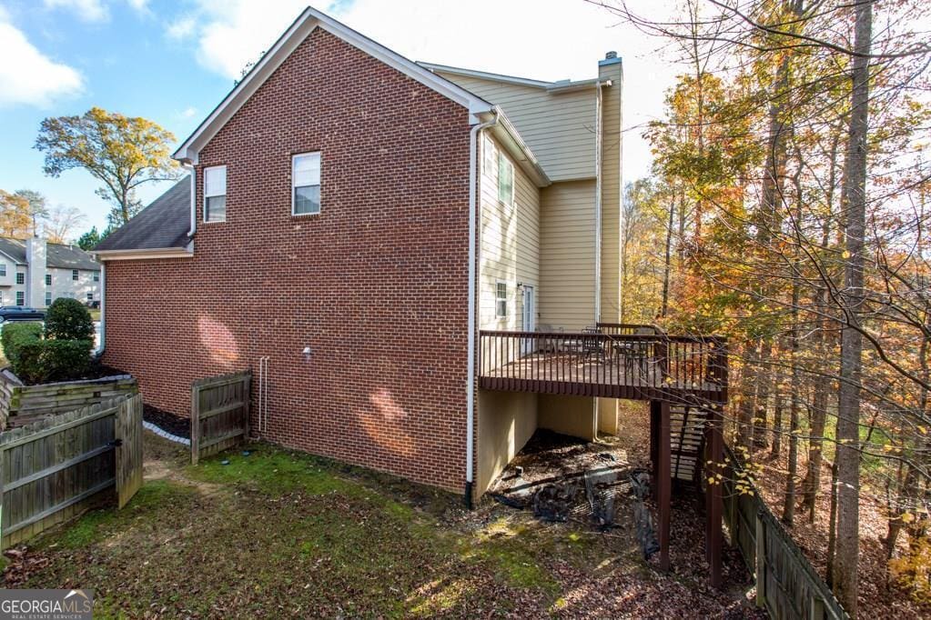 345 Manning Ct, South Fulton, GA 30349 - view of property exterior with a chimney, a wooden deck, fence, and stairway