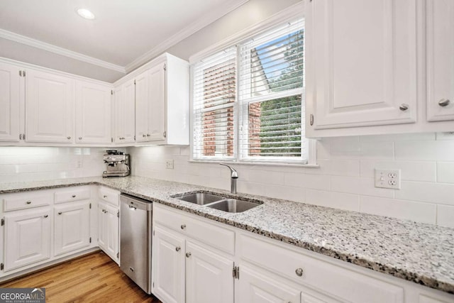 kitchen with dishwasher, a sink, ornamental molding, white cabinets, and healthy amount of natural light