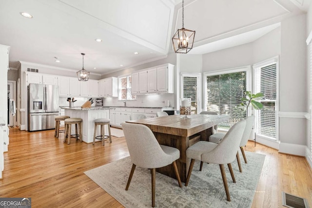 dining space featuring a chandelier, light wood-style floors, baseboards, recessed lighting, and crown molding