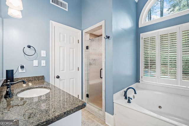 bathroom featuring a shower stall, a whirlpool tub, and vanity