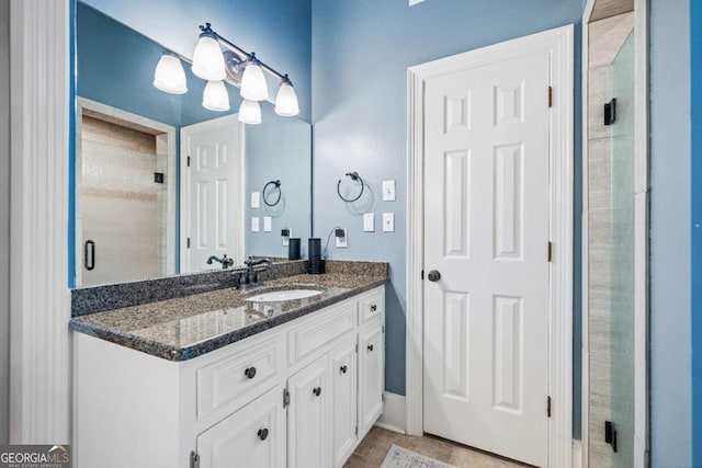 bathroom with a shower stall, vanity, and baseboards