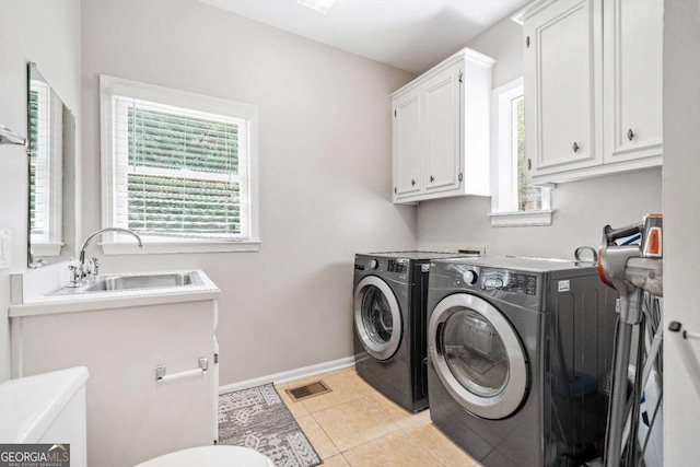 clothes washing area featuring independent washer and dryer, baseboards, cabinet space, and light tile patterned floors