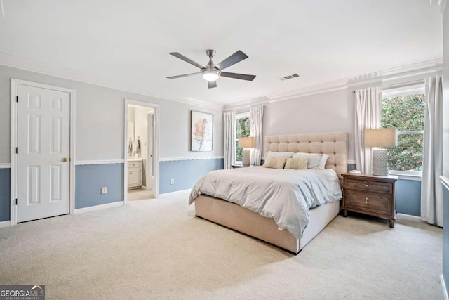 carpeted bedroom featuring ornamental molding, baseboards, ceiling fan, and connected bathroom