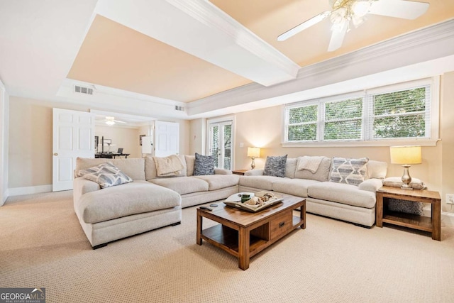carpeted living room featuring ceiling fan, crown molding, a raised ceiling, and baseboards