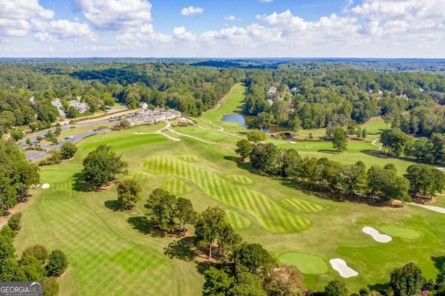 aerial view of a heavily wooded area, a large body of water, and a golf club
