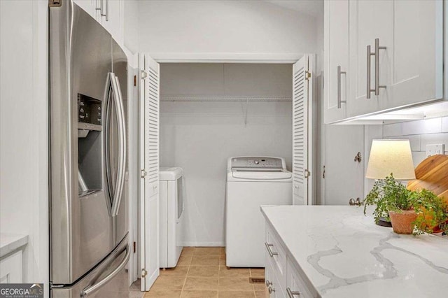 clothes washing area featuring washing machine and clothes dryer and light tile patterned floors
