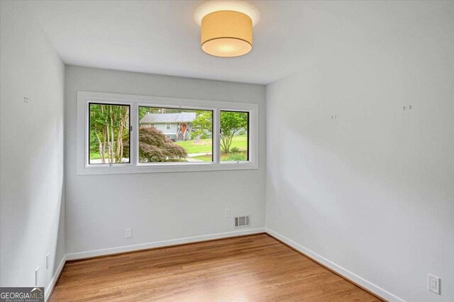 empty room featuring light wood finished floors and baseboards