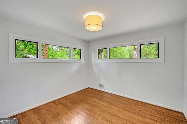 empty room featuring wood finished floors and baseboards