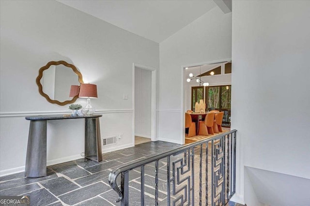 hall with baseboards and high vaulted ceiling