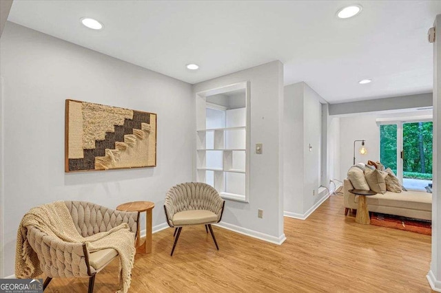 living area with baseboards, light wood-style flooring, and recessed lighting