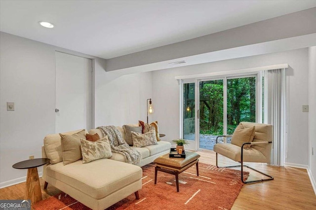 living room featuring light wood-style flooring, baseboards, and recessed lighting