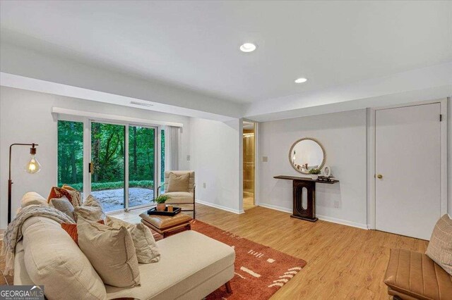 living area featuring light wood-style floors, baseboards, and recessed lighting