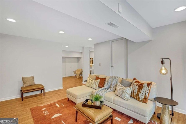 living room featuring light wood finished floors, recessed lighting, and baseboards