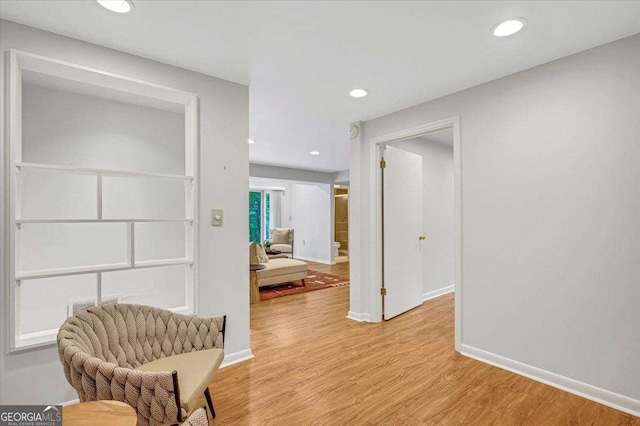 hall with light wood-style floors, baseboards, and recessed lighting