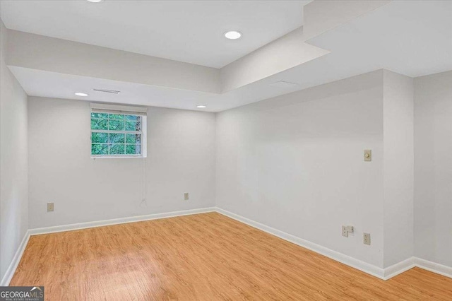 empty room featuring wood finished floors, baseboards, and recessed lighting