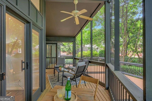 sunroom with ceiling fan and vaulted ceiling
