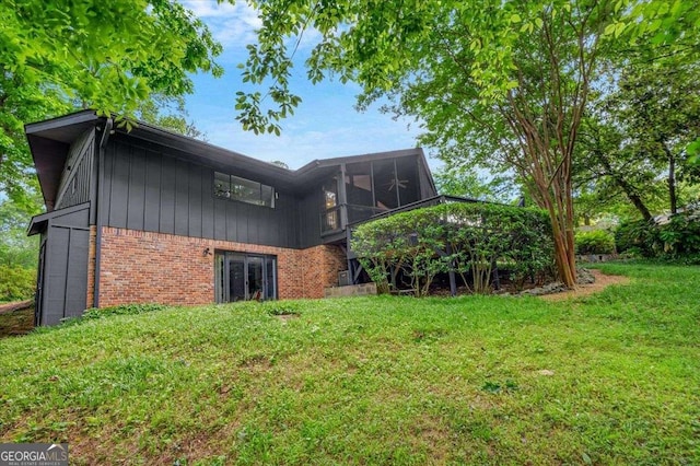 rear view of house with brick siding and a lawn