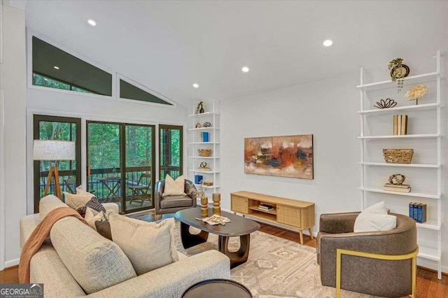 living area with wood finished floors, recessed lighting, and high vaulted ceiling