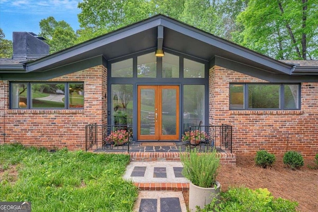 doorway to property featuring french doors and brick siding