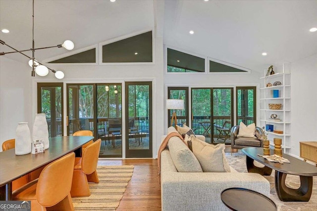 living area with wood finished floors, high vaulted ceiling, recessed lighting, and french doors