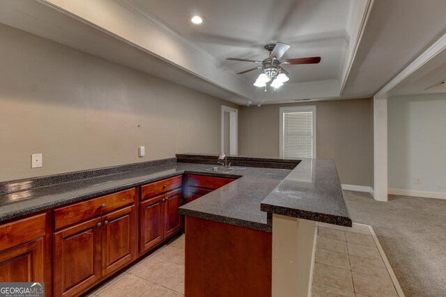135 Magnolia Dr, Oxford, GA 30054 - kitchen with a sink, a peninsula, a ceiling fan, a tray ceiling, and dark countertops