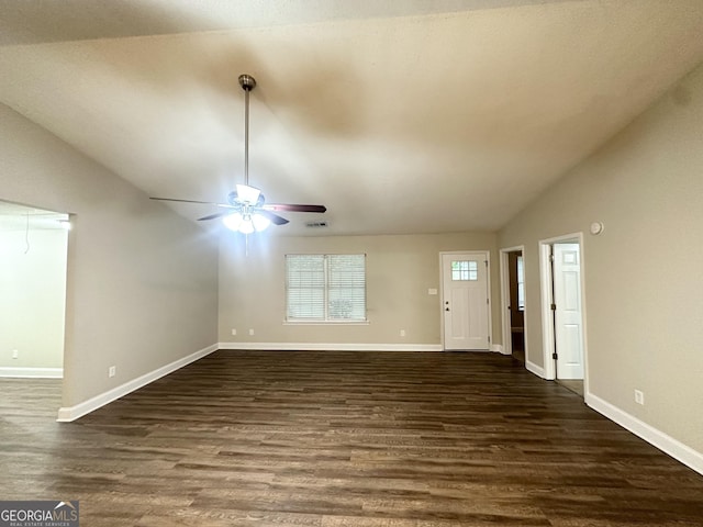 221 Courthouse Park Dr, Temple, GA 30179 - unfurnished living room with dark wood-type flooring, visible vents, vaulted ceiling, a ceiling fan, and baseboards