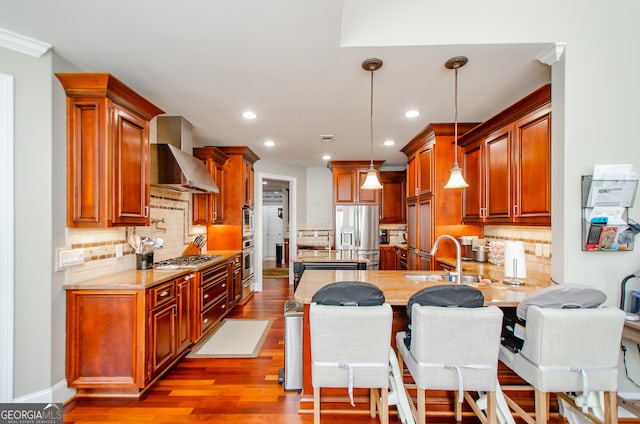 1340 Traditions Way, Jefferson, GA 30549 - kitchen with wall chimney range hood, appliances with stainless steel finishes, a sink, a peninsula, and backsplash