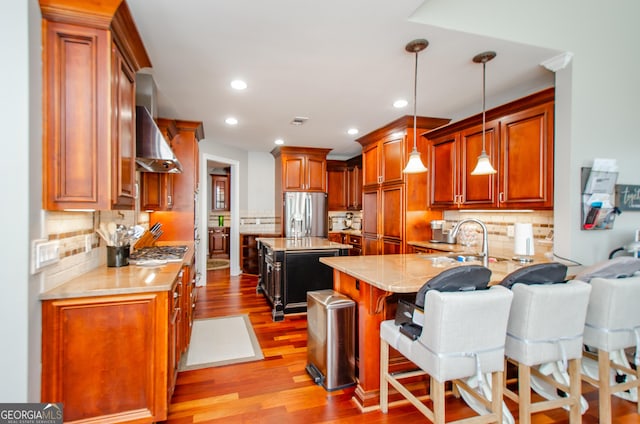 1340 Traditions Way, Jefferson, GA 30549 - kitchen featuring stainless steel appliances, wall chimney exhaust hood, tasteful backsplash, wood finished floors, and a sink