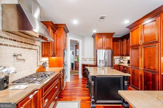 1340 Traditions Way, Jefferson, GA 30549 - kitchen featuring appliances with stainless steel finishes, wall chimney exhaust hood, tasteful backsplash, light stone counters, and dark wood-type flooring