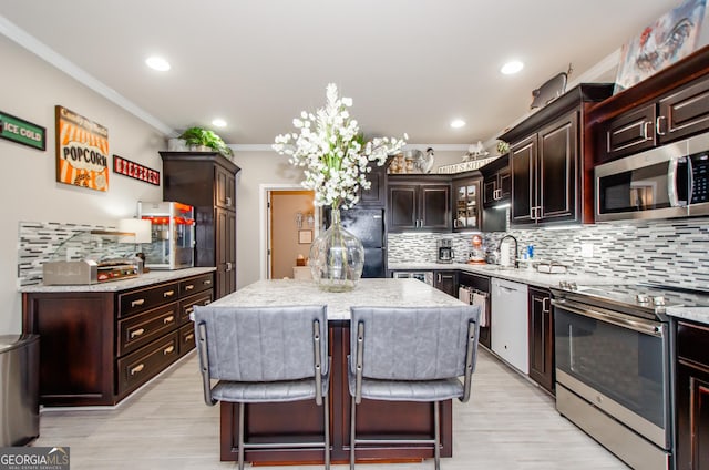1340 Traditions Way, Jefferson, GA 30549 - kitchen featuring stainless steel appliances, decorative backsplash, ornamental molding, a kitchen island, and a sink