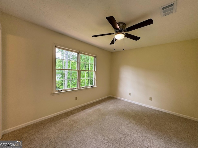 carpeted spare room with baseboards and a ceiling fan