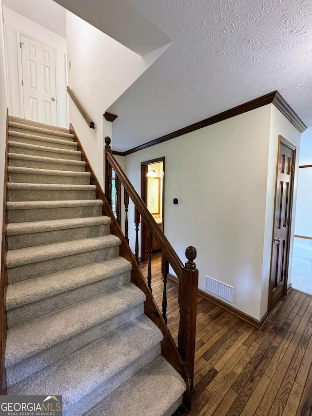 5307 Red Rock Trce, Powder Springs, GA 30127 - stairs with wood-type flooring, ornamental molding, baseboards, and a textured ceiling