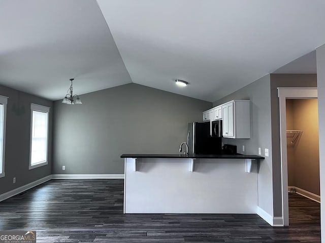 201 Jones St, Dalton, GA 30720 - kitchen featuring a peninsula, freestanding refrigerator, dark countertops, white cabinets, and vaulted ceiling