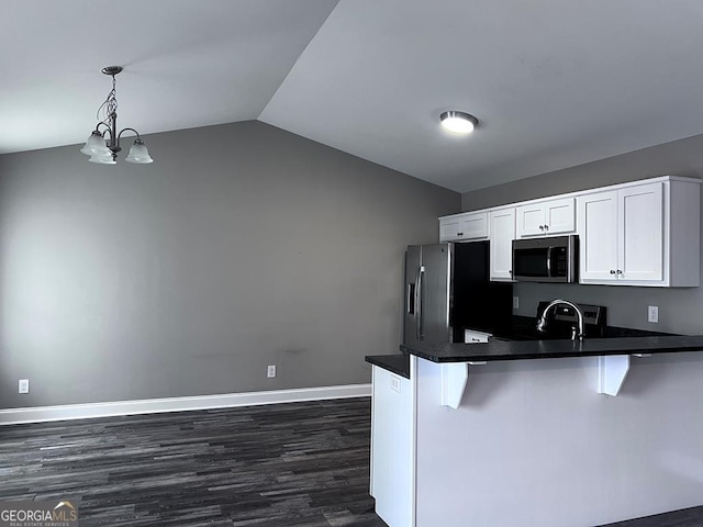 201 Jones St, Dalton, GA 30720 - kitchen featuring a peninsula, lofted ceiling, dark wood-style floors, white cabinets, and appliances with stainless steel finishes