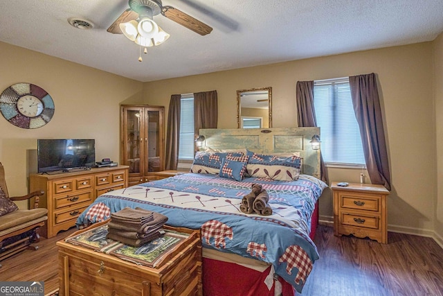 bedroom with a ceiling fan, baseboards, a textured ceiling, and wood finished floors