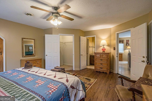 bedroom featuring a closet, visible vents, a textured ceiling, and wood finished floors