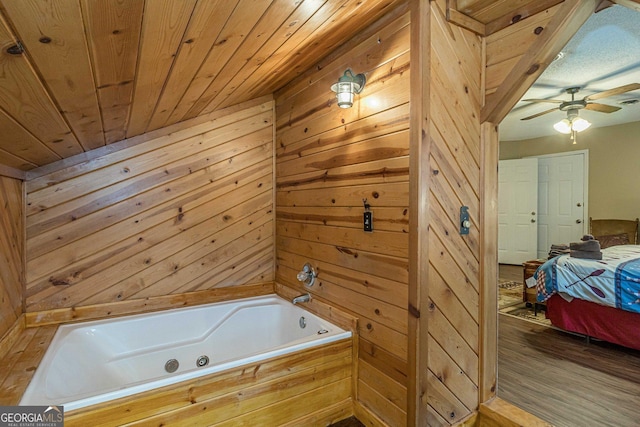 ensuite bathroom with a whirlpool tub, connected bathroom, wood ceiling, and wooden walls
