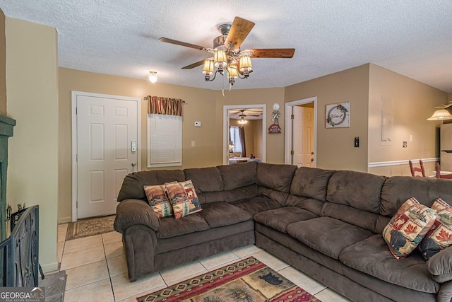 living room featuring light tile patterned flooring, a textured ceiling, and a ceiling fan