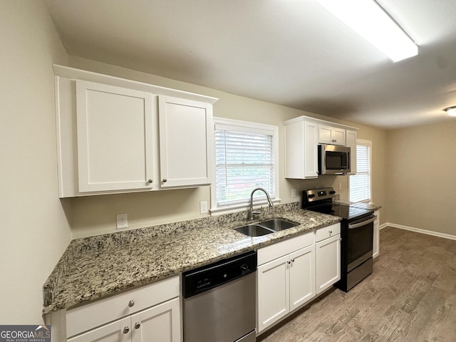 1814 Mary Lou Ln SE, Atlanta, GA 30316 - kitchen with light stone counters, a sink, white cabinetry, light wood-style floors, and stainless steel appliances