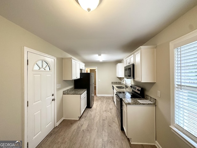 1814 Mary Lou Ln SE, Atlanta, GA 30316 - kitchen featuring a sink, light wood finished floors, white cabinets, baseboards, and appliances with stainless steel finishes