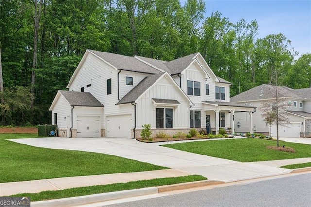 modern inspired farmhouse featuring board and batten siding, a front lawn, an attached garage, and concrete driveway