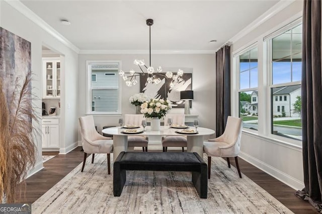 dining room with baseboards, dark wood-type flooring, ornamental molding, and a chandelier