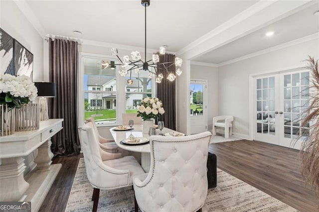 dining room with french doors, wood finished floors, a chandelier, crown molding, and baseboards