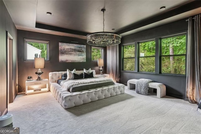 carpeted bedroom with a chandelier and a tray ceiling
