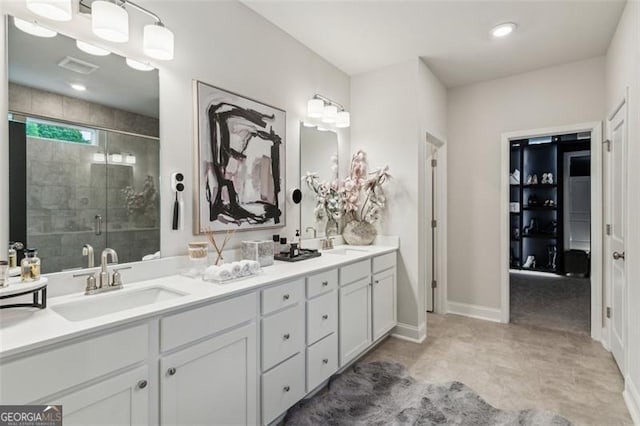 full bath featuring a shower stall, double vanity, and baseboards