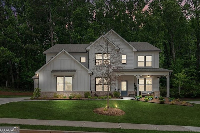 modern farmhouse style home featuring board and batten siding, a porch, and a front lawn