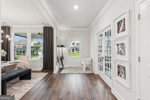 foyer featuring dark wood-type flooring, crown molding, baseboards, and french doors