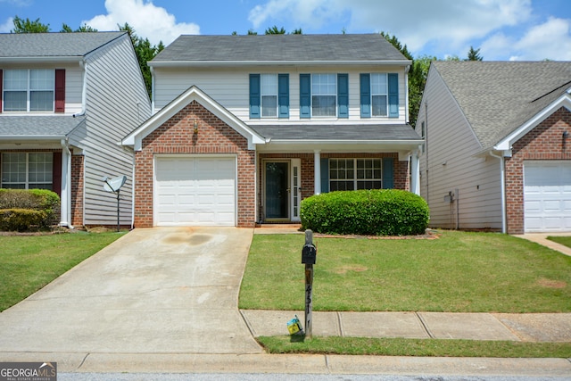 traditional home with brick siding, driveway, a front yard, and an attached garage