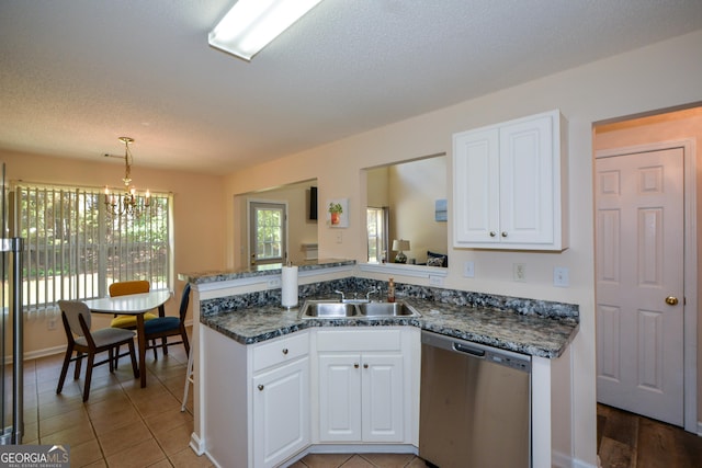 kitchen featuring dishwasher, a sink, a chandelier, white cabinets, and a peninsula