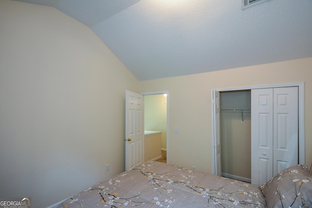 unfurnished bedroom with lofted ceiling and a closet